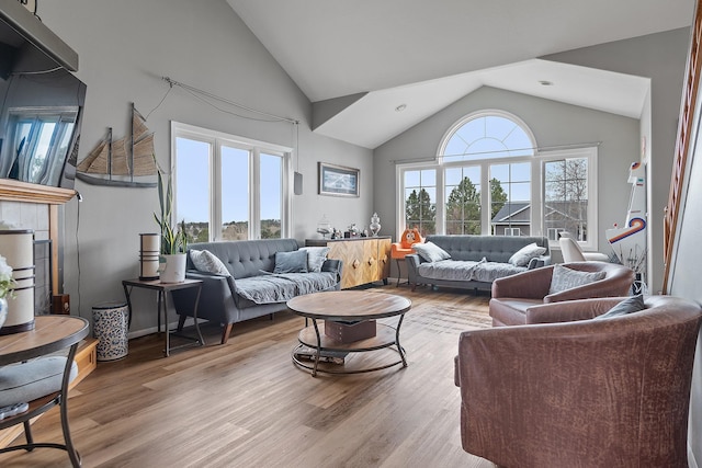 living area with light wood finished floors and high vaulted ceiling