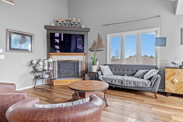 living room featuring baseboards, wood finished floors, and a fireplace