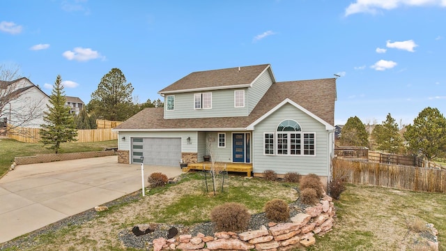 traditional-style home featuring driveway, a front lawn, fence, and roof with shingles