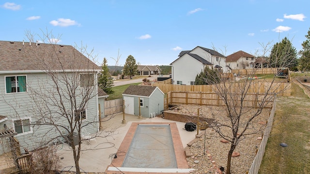 exterior space featuring a fenced backyard, an outbuilding, a residential view, and a shed