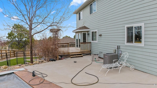 view of patio featuring central AC, fence, and a deck