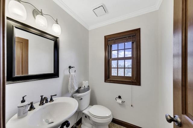 half bath featuring crown molding, visible vents, toilet, a sink, and baseboards