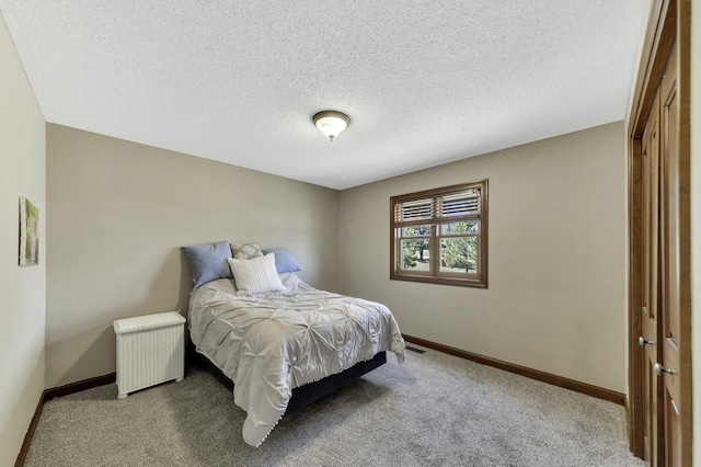 carpeted bedroom with visible vents, baseboards, and a textured ceiling