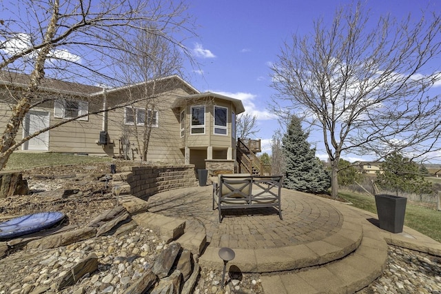 rear view of house featuring a patio and stairway