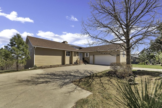 ranch-style home with a chimney, a garage, and concrete driveway