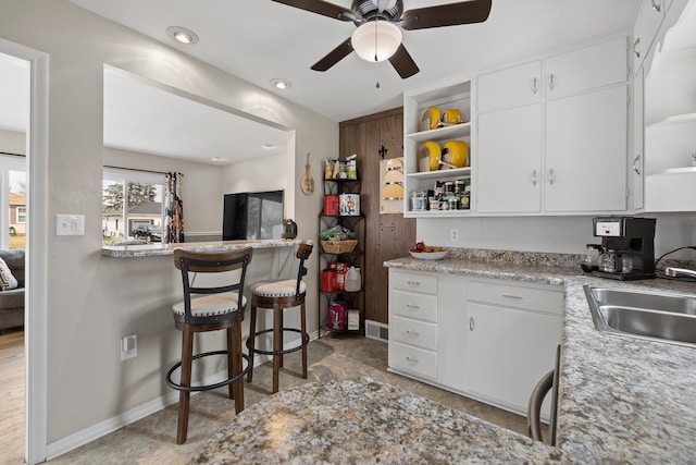 4101 Pleasant Dr, Rapid City, SD 57702 - kitchen with white cabinets, open shelves, baseboards, a sink, and a ceiling fan