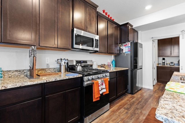 552 Other, Rapid City, SD 57703 - kitchen with light stone counters, recessed lighting, dark brown cabinets, dark wood-type flooring, and stainless steel appliances
