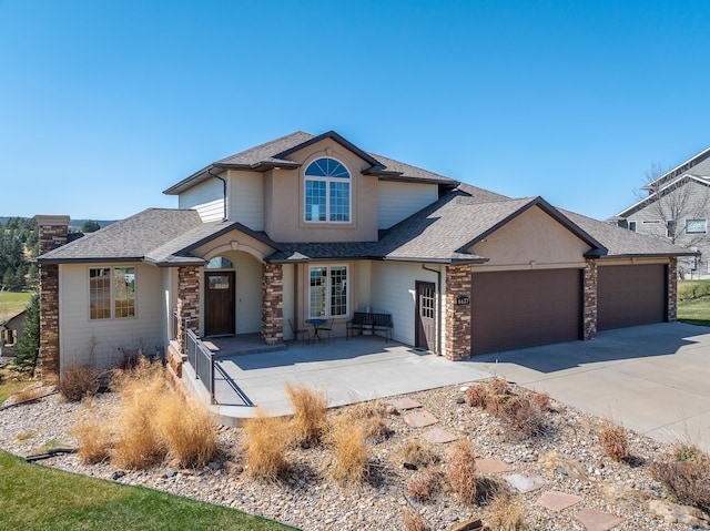 6627 Kennemer Dr, Rapid City, SD 57702 - view of front of house featuring an attached garage, stone siding, driveway, and roof with shingles