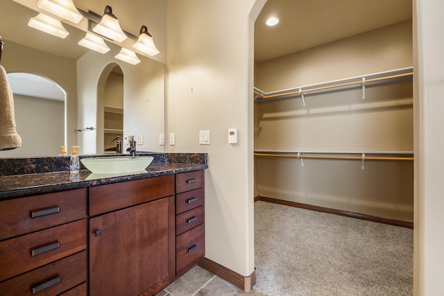 6627 Kennemer Dr, Rapid City, SD 57702 - bathroom with vanity, baseboards, and a walk in closet