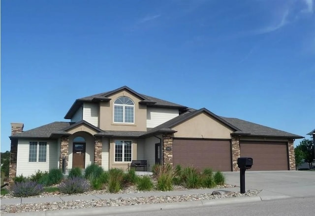 6627 Kennemer Dr, Rapid City, SD 57702 - view of front of property with driveway, a garage, stucco siding, and stone siding