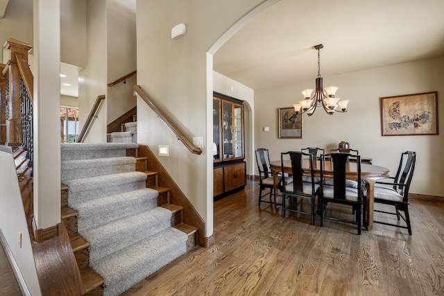 6627 Kennemer Dr, Rapid City, SD 57702 - dining space with baseboards, stairway, arched walkways, and wood finished floors