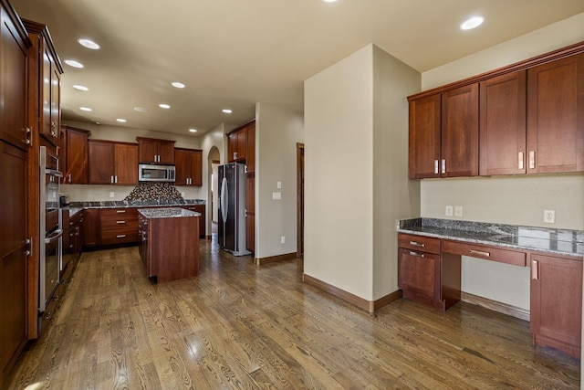 6627 Kennemer Dr, Rapid City, SD 57702 - kitchen with dark wood-style flooring, built in study area, recessed lighting, a center island, and stainless steel appliances