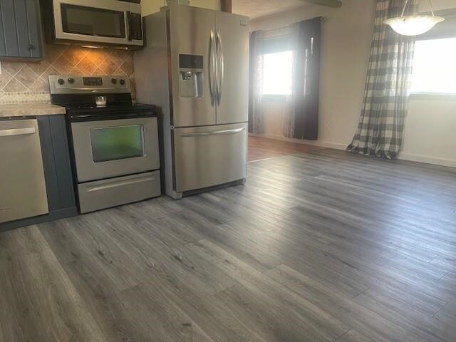 1021 Omaha St, Belle Fourche, SD 57717 - kitchen with stainless steel appliances, tasteful backsplash, baseboards, wood finished floors, and gray cabinets
