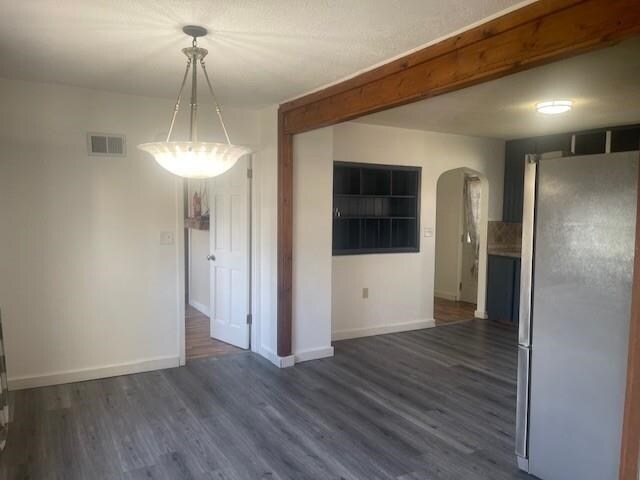 1021 Omaha St, Belle Fourche, SD 57717 - interior space featuring baseboards, visible vents, arched walkways, and dark wood finished floors
