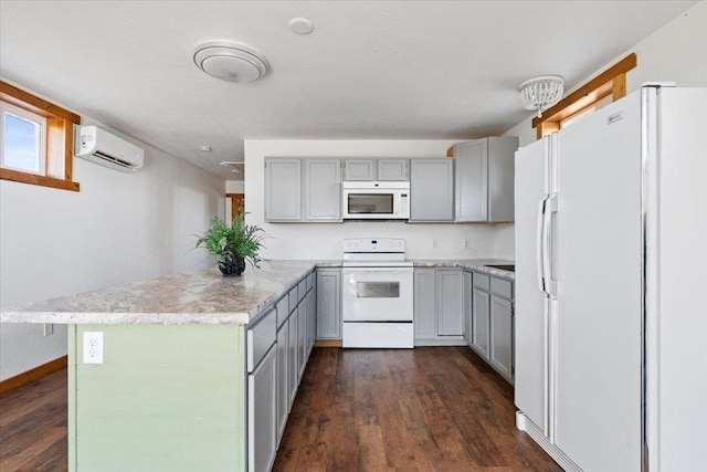 kitchen with dark wood-type flooring, a peninsula, gray cabinetry, and white appliances