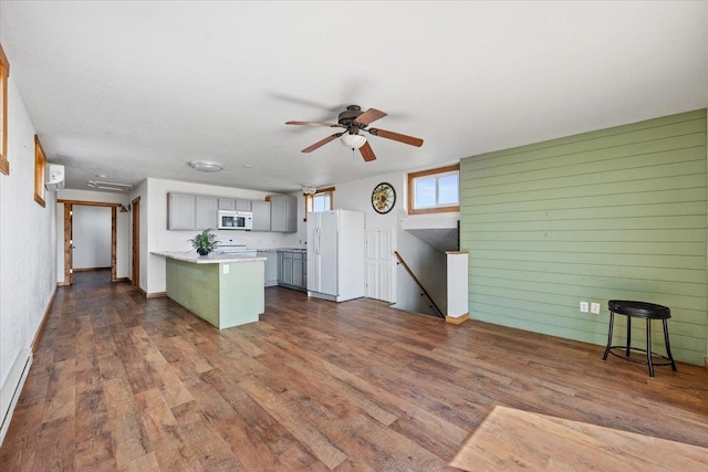 kitchen featuring gray cabinets, white appliances, a peninsula, dark wood-type flooring, and ceiling fan