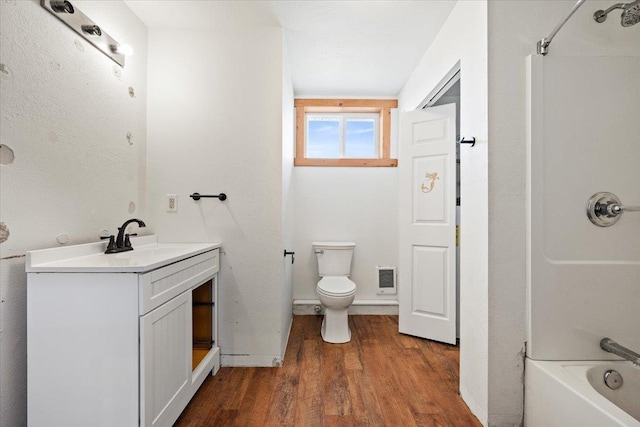 bathroom with visible vents, shower / washtub combination, toilet, vanity, and wood finished floors