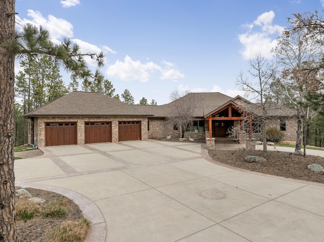 2724 Diamond Oak Pl, Rapid City, SD 57702 - view of front of house with an attached garage, a shingled roof, driveway, and stone siding
