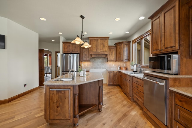 2724 Diamond Oak Pl, Rapid City, SD 57702 - kitchen with arched walkways, light wood-type flooring, a sink, and appliances with stainless steel finishes