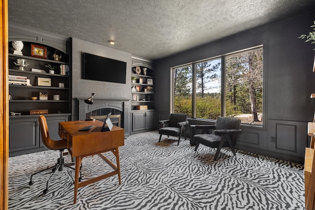 2724 Diamond Oak Pl, Rapid City, SD 57702 - living area featuring carpet floors, built in shelves, a glass covered fireplace, and a textured ceiling