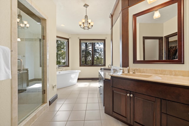 2724 Diamond Oak Pl, Rapid City, SD 57702 - full bathroom featuring a freestanding tub, an inviting chandelier, vanity, tile patterned floors, and a stall shower