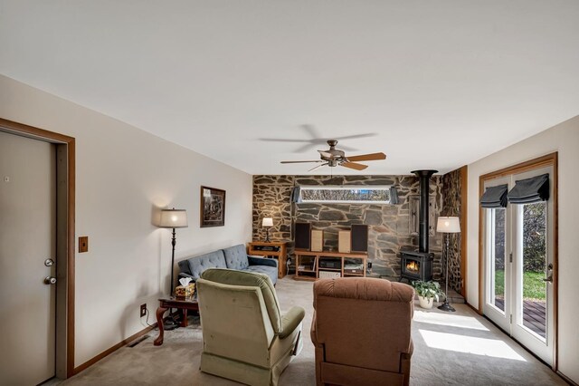 1106 Allen St, Rapid City, SD 57701 - carpeted living area featuring a wood stove, ceiling fan, and baseboards