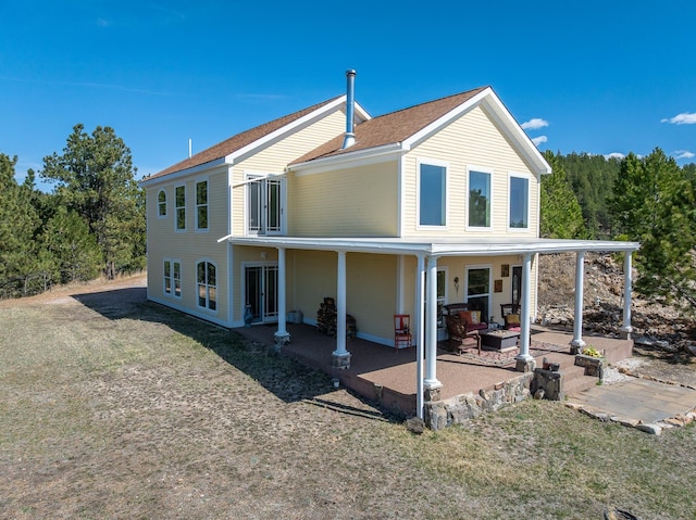 11583 Pay Dirt Pass, Custer, SD 57730 - back of house featuring a lawn, a patio, and roof with shingles