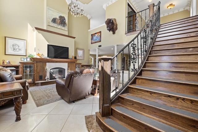 11583 Pay Dirt Pass, Custer, SD 57730 - living area featuring a high ceiling, a glass covered fireplace, tile patterned floors, and stairs