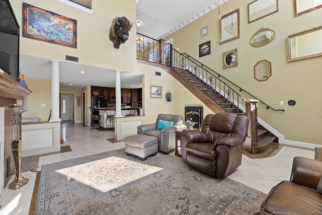 11583 Pay Dirt Pass, Custer, SD 57730 - living room featuring light tile patterned flooring, a high ceiling, baseboards, visible vents, and decorative columns