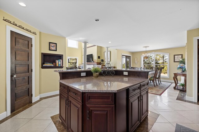 11583 Pay Dirt Pass, Custer, SD 57730 - kitchen featuring a center island, baseboards, light stone counters, and light tile patterned floors