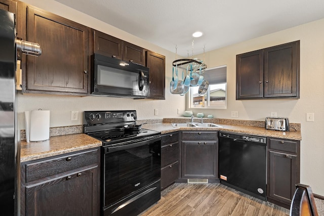 2207 Other, Rapid City, SD 57703 - kitchen featuring light wood finished floors, light countertops, dark brown cabinets, a sink, and black appliances