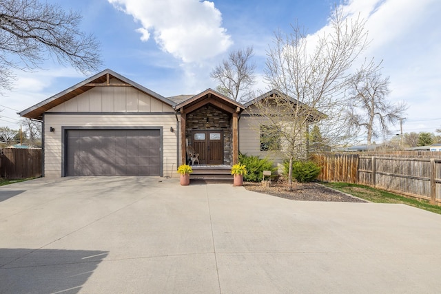 3818 W Main St, Rapid City, SD 57702 - ranch-style home with an attached garage, fence, stone siding, and driveway