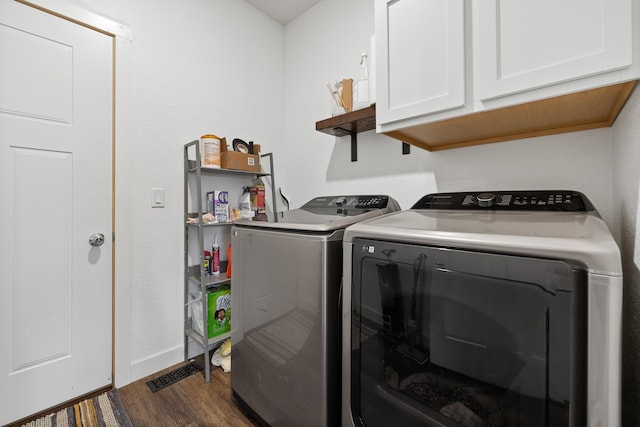 3818 W Main St, Rapid City, SD 57702 - clothes washing area with dark wood-style floors, visible vents, washing machine and dryer, baseboards, and cabinet space