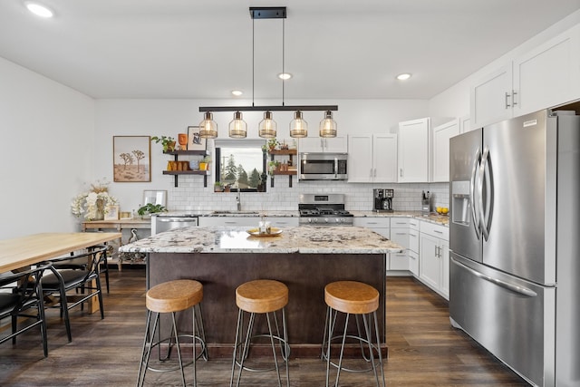 3818 W Main St, Rapid City, SD 57702 - kitchen with stainless steel appliances, dark wood-style floors, a sink, decorative backsplash, and a kitchen island