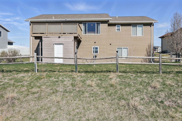 rear view of house with a fenced backyard and a yard