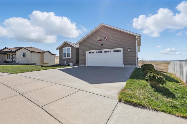 single story home with a garage, a front yard, and concrete driveway