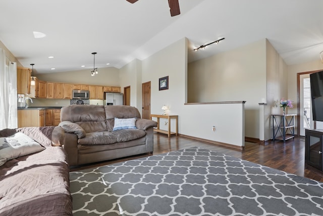 living area with vaulted ceiling, rail lighting, a ceiling fan, and dark wood-style floors
