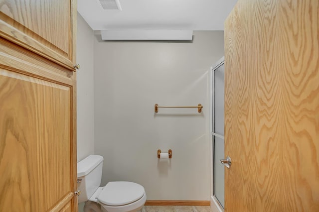 full bathroom with a shower stall, toilet, visible vents, and baseboards