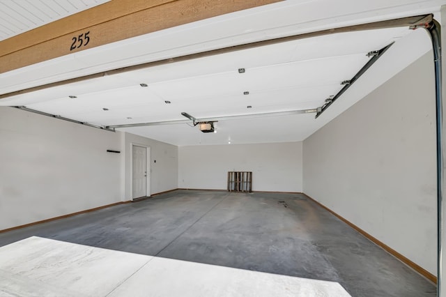 garage featuring a garage door opener and baseboards