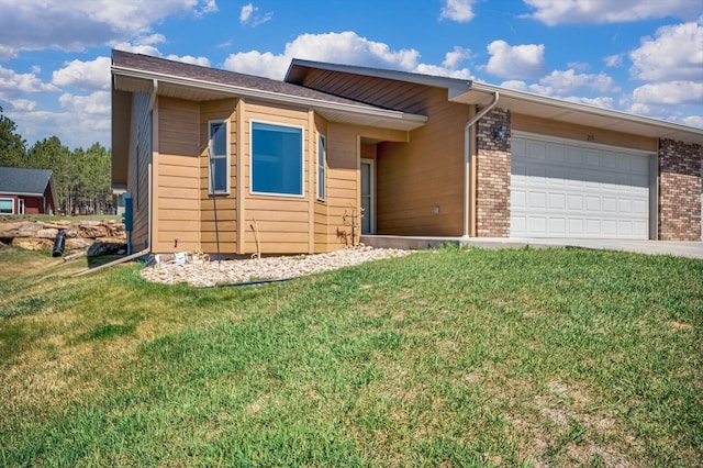 view of front of property with an attached garage, driveway, a front lawn, and brick siding