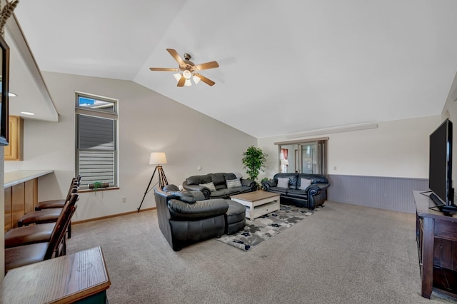 living area featuring vaulted ceiling, a ceiling fan, a wainscoted wall, and carpet