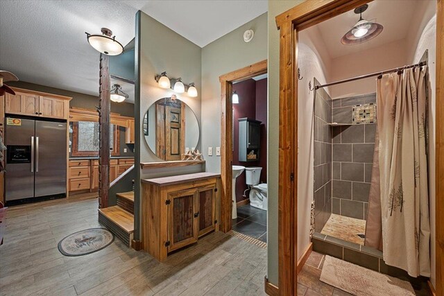 20097 Higgins Gulch Rd, Spearfish, SD 57783 - bathroom featuring vanity, tiled shower, and wood finished floors