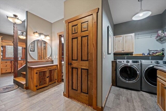 20097 Higgins Gulch Rd, Spearfish, SD 57783 - laundry area featuring light wood-type flooring, cabinet space, independent washer and dryer, and baseboards