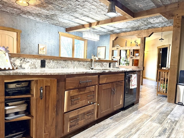 20097 Higgins Gulch Rd, Spearfish, SD 57783 - kitchen featuring a textured wall, light stone counters, a sink, light wood finished floors, and dishwasher