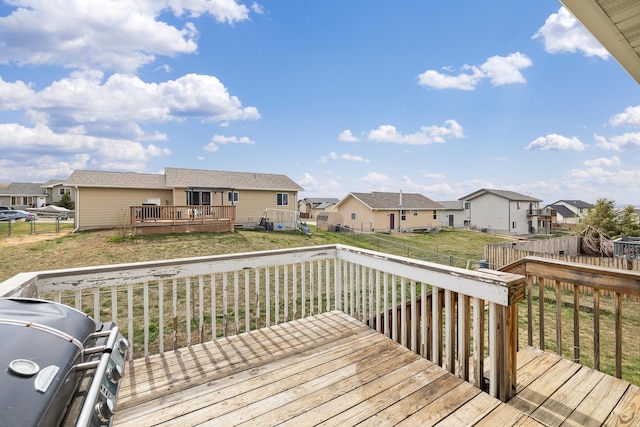 deck featuring a residential view, a lawn, and a fenced backyard
