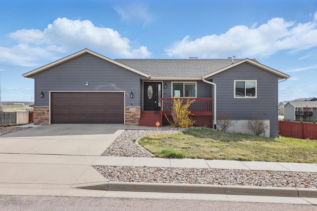 single story home featuring roof with shingles, a front lawn, concrete driveway, fence, and an attached garage