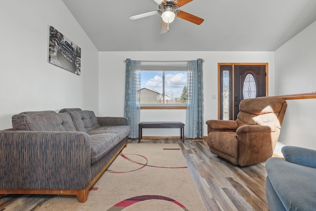 living room featuring vaulted ceiling, a ceiling fan, and wood finished floors
