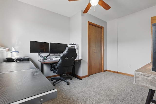carpeted office space featuring ceiling fan and baseboards