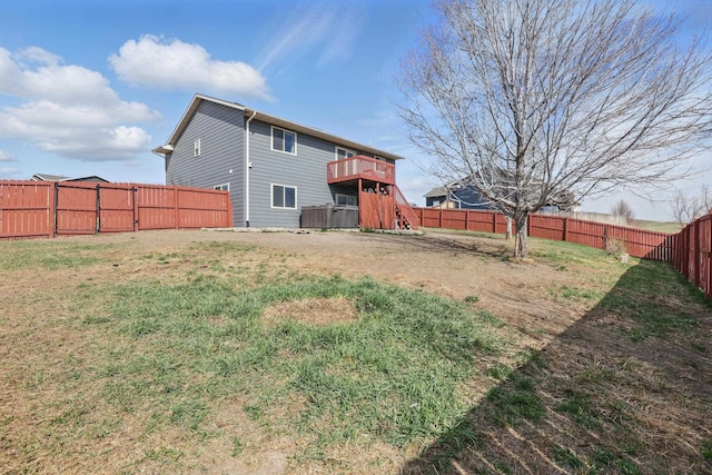 rear view of property featuring a fenced backyard, a deck, and a lawn