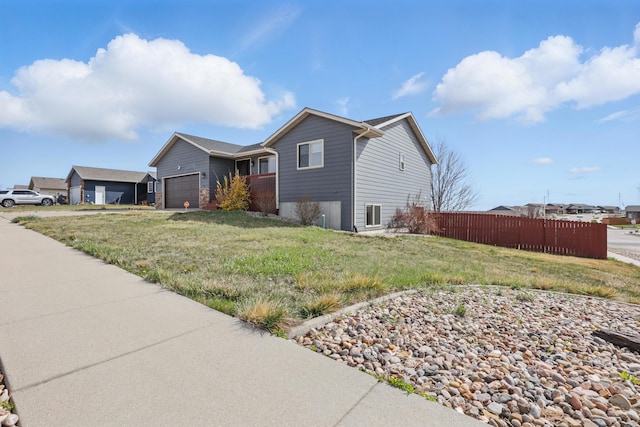 view of home's exterior with fence, a lawn, and a garage